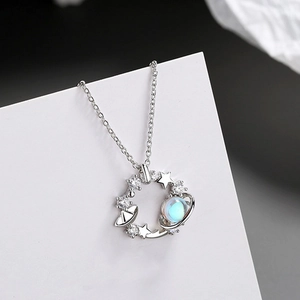 Macro detail of silver celestial necklace with opal planet and cubic zirconia stars