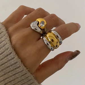 Retro two-tone chunky rings with pear-shaped stones worn by a model in knitwear