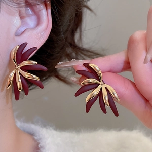 Detail of 18k gold plated floral earrings with matte burgundy petals and vintage aesthetic