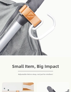 Detail of a brown leather stroller hook with adjustable Velcro strap and a white S-hook