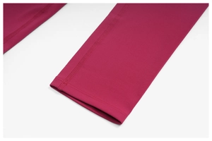 Gros plan détaillé des coutures plates sur le tissu d'un pantalon de yoga magenta foncé