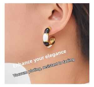 Detail of vacuum plated C-shaped earrings showing elegant gold finish and enamel inlay
