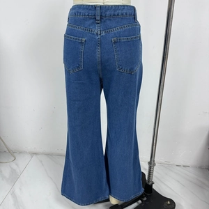 Détail des poches arrière et de la texture du denim délavé du jean bleu évasé