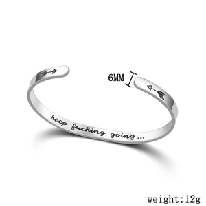 Close-up of engraved motivational quote on silver titanium steel cuff bracelet