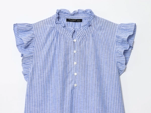 Détail d'une chemise en coton rayé bleu clair avec col à volants et petits boutons