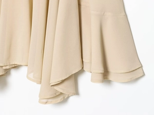 Détail de l'ourlet à volants superposés sur le haut en georgette couleur abricot