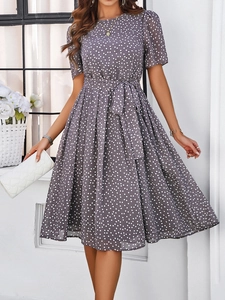 Détail d'une robe grise à pois avec ceinture nouée et manches courtes sur modèle