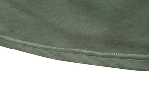 Détail de la double couture sur l'ourlet d'un polo en coton vert olive