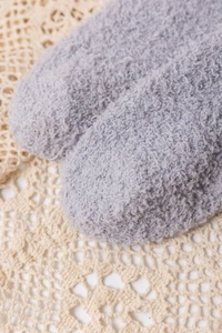 Close-up of gray coral fleece over-knee socks showing soft plush texture and toe detail