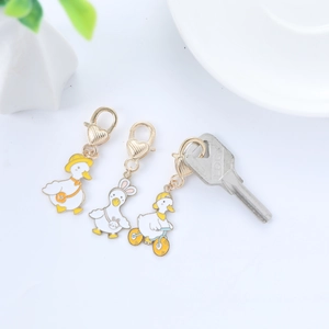 Three cute enamel duck keychains featuring a hat, bunny ears, and bike with heart clips