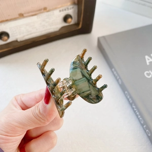 Minimalist marble pattern acetate hair claw clip for women shown in a vintage setting