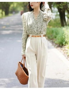 Elegant thin brown leather belt with metal buckle on high-waist trousers for women