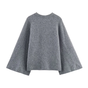 Détails de la texture du manteau en laine grise et design des manches larges en gros plan