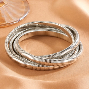 Détail macro du bracelet chaîne serpent multicouche en argent sur soie orange