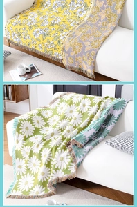 Close-up of jacquard knit floral blanket with yellow daisies and colorful fringe trim