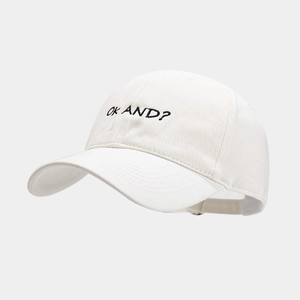 Close-up of black 'OK AND?' embroidery on white cotton twill baseball cap fabric