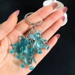 Close-up of three blue jelly gummy bear pendants on a high-quality metal keychain