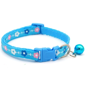 Dettaglio del collare blu per animali con stampa floreale, fibbia e campanello in metallo