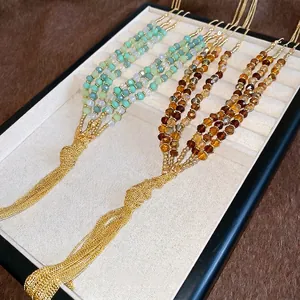 Ethnic style beaded tassel necklace with layered crystal beads in green and amber tones