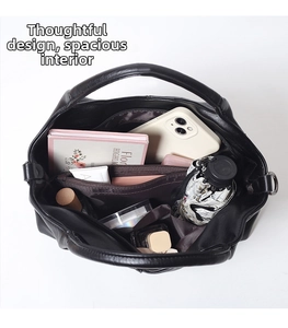 Detailed interior of black leather tote bag with compartments for phone and umbrella