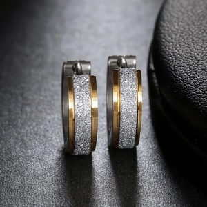 Detailed macro shot of two-tone stainless steel hoop earrings with silver frosted texture