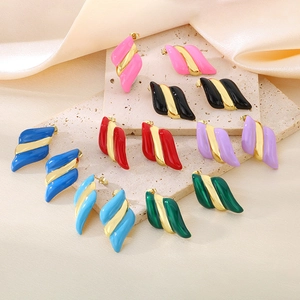 Détail de boucles d'oreilles vagues torsadées plaquées or 18 carats et émail multicolore