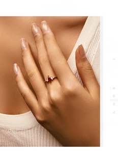 Close-up of elegant gold ring with marquise-cut ruby and diamond accents on model hand