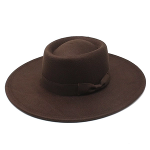 Détail d'un chapeau en laine marron foncé avec large bord et ruban gros-grain décoré
