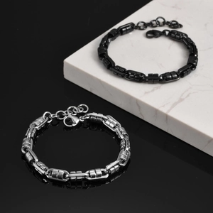 Detailed shot of black and silver square link steel bracelets on marble and black surface