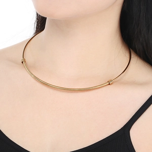Close-up of golden twist steel torque necklace with spiral texture on a female model