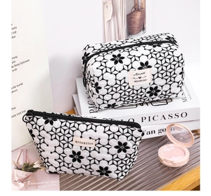 Detail of two floral quilted pouches on books with cosmetics for stylish organization