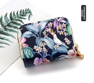 Detail of tropical print zip wallet with pink floral and white cockatoo pattern on navy