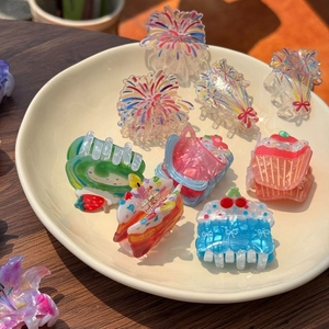 Detailed view of colorful acrylic flower and cake hair clips on a ceramic plate