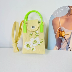 Detail of yellow knit phone bag with floral pattern and bright green handle grip