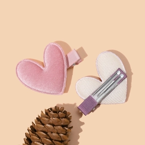Detailed view of pink velvet heart hair clips showing the front texture and metal clip back