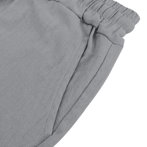 Detail of grey linen pants featuring elastic waistband and side pocket stitching