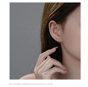 Minimalist s999 sterling silver small hoop earrings and ear cuff on a model's ear