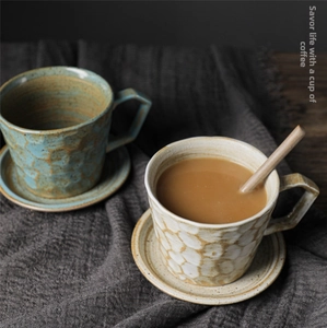 Detail of vintage ceramic coffee cup set with textured glaze and wooden stir spoon