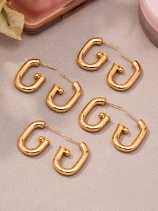 Détail des boucles d'oreilles en U plaquées or 18 carats avec finition métal poli