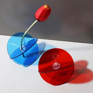Close-up of geometric acrylic vases in red and blue with artistic shadows and reflections