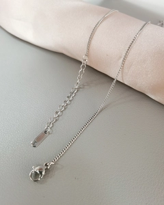 Detail of silver stainless steel curb chain with lobster clasp and adjustable links