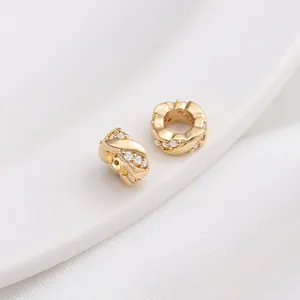 Detail of 14K gold plated bead with cubic zirconia and intricate woven pattern
