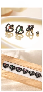 Detailed view of heart-shaped steel earrings with colorful drop-cut gemstones in black frames