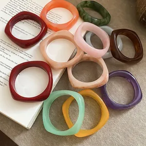 Colorful resin geometric bangles in various retro shades on a vintage background