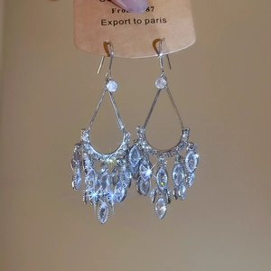 Detailed macro view of silver tassel drop earrings with zircon teardrop crystal pendants
