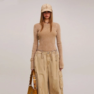 Vista a figura intera di una donna con top in maglia gialla vintage e pantaloni cargo