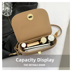 Detail view showing interior capacity of khaki saddle bag with scarf chain strap