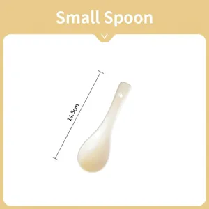 Detail view of small white ceramic spoon with a 14.5cm long handle and hanging hole