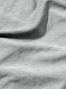 Macro del tessuto sportivo grigio chiaro che mostra la trama a maglia e il drappeggio