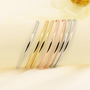 Detailed display of minimalist 18k gold-plated bangles in silver, gold and rose gold